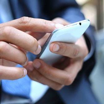 Image of two hands holding a cell phone after speaking with a bilingual answering service